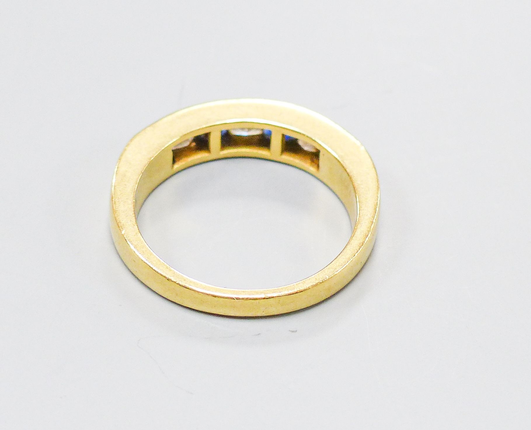 A modern 18ct gold, four stone sapphire and three stone diamond set half hoop ring, size P, gross weight 6.1 grams.